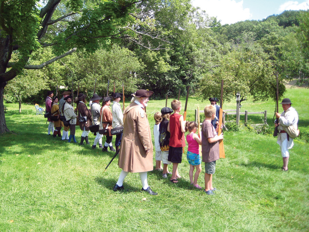 HOW IT’S DONE: Militia members show the kids how the founders of the American Revolution trained for battle.