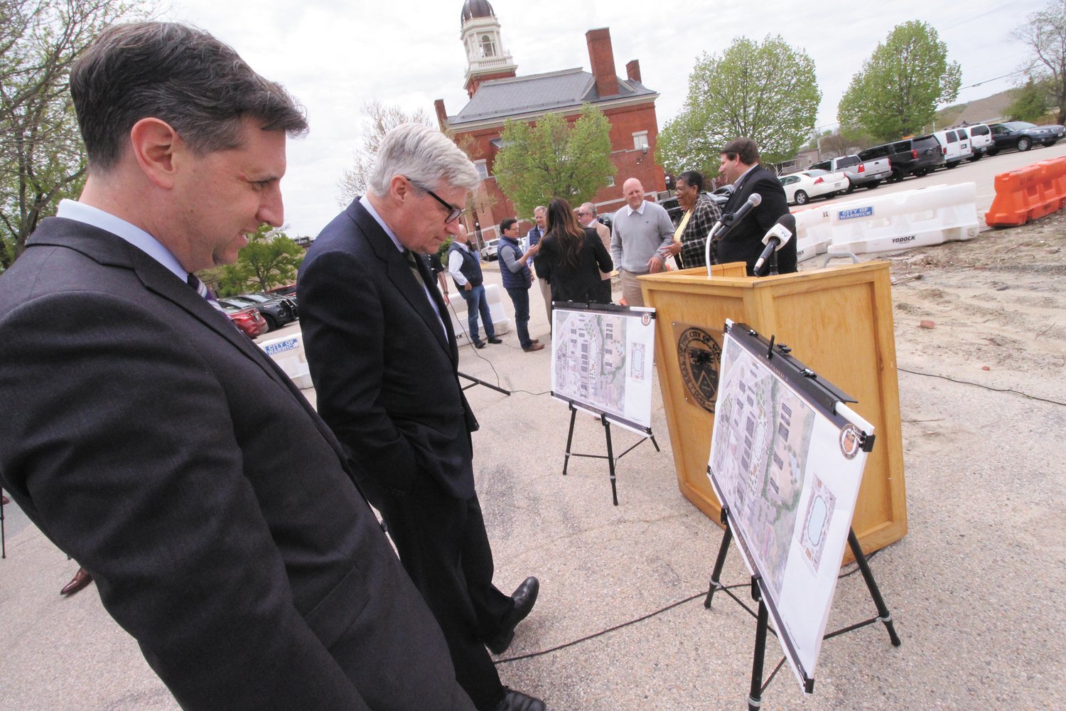 ALL IN THE PLANS: Senator Sheldon Whitehouse and State Treasurer Seth Magaziner look over plans for the proposed Warwick Plaza behind Warwick City Hall.