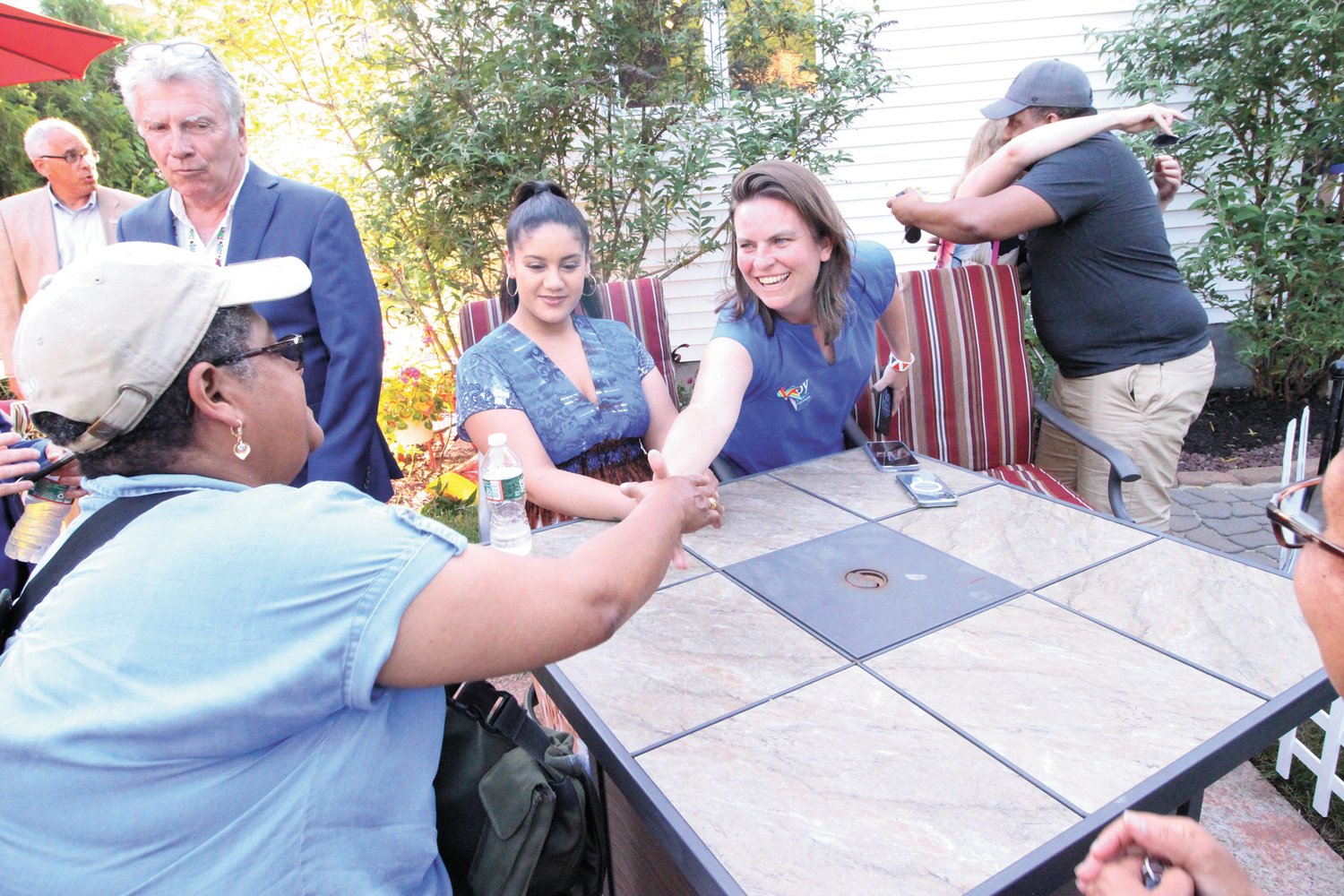 TABLE REACH: Second Congressional District Democratic candidate Joy Fox greets people after arriving at the Latino Public Radio BBQ  held Saturday at the station in Cranston. (Cranston Herald photos)
